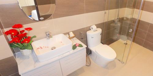 潘切Huy Đạt Hotel的一间带水槽的浴室和一个带红色鲜花的卫生间