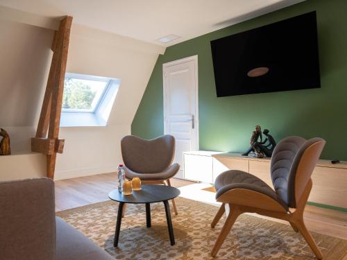 布什内斯博利厄城堡酒店的客厅配有两把椅子和墙上的电视