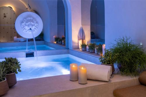 巴黎Hôtel Vinci Due & Spa的一座带两个蜡烛和植物浴缸的大型游泳池
