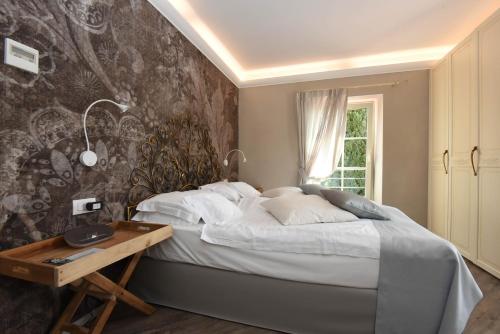 勒威诺Relais Villa Porta的一间卧室配有床和壁画