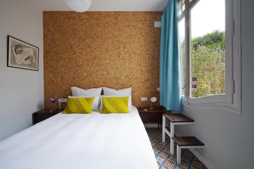 巴塞罗那numa l Roca Rooms & Apartments的卧室配有一张带黄色枕头的大型白色床。