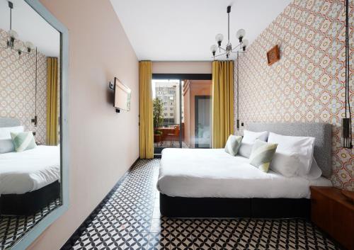 巴塞罗那numa l Roca Rooms & Apartments的酒店客房,设有两张床和镜子