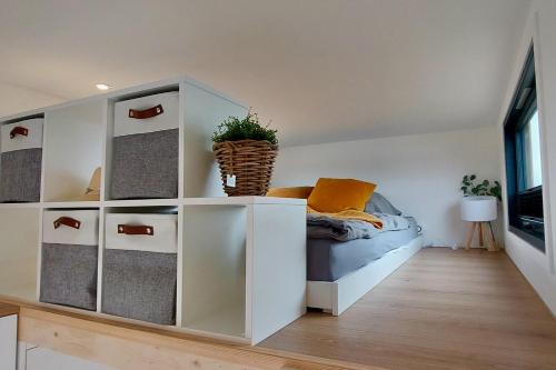 ElsflethWinzig Wohnen Tiny House Frigg direkt am Weserstrand的一间卧室配有床和白色橱柜