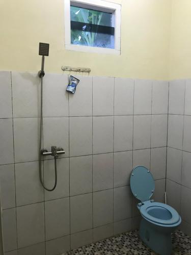 丹戎槟榔OYO 90998 Wisma Pinggir的一间带蓝色卫生间的浴室和窗户。