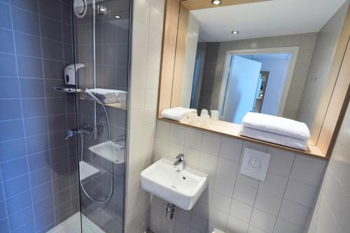 梅里尼亚克波尔多西部 - 梅里尼亚克机场普瑞米尔经典酒店的浴室配有盥洗盆和带镜子的淋浴