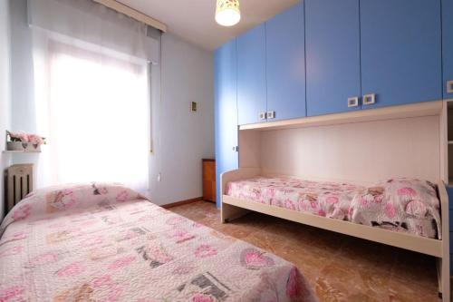 皮内托Malibù 5 Pineto Vacanza的一间卧室配有两张床和蓝色橱柜。