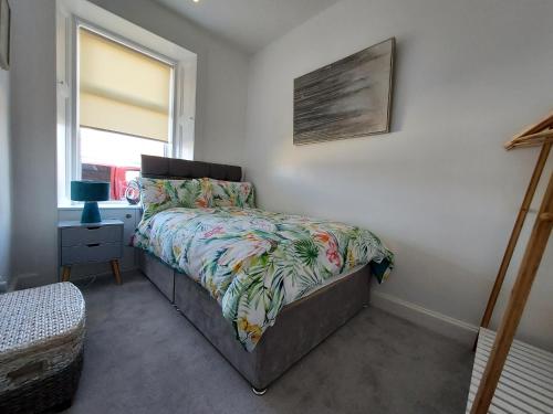 LilliesleafDuke Street Apartment的一间卧室配有一张带花卉床罩的床和窗户。