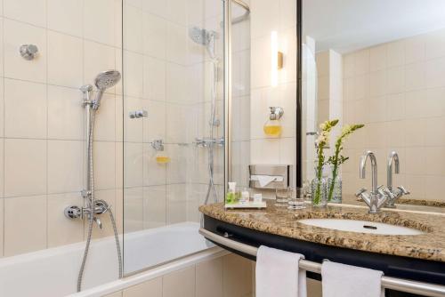 波茨坦波茨坦NH酒店的带淋浴、盥洗盆和浴缸的浴室