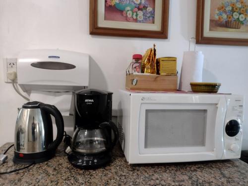 坦迪尔Casa en Tandil的厨房柜台配有微波炉和咖啡壶
