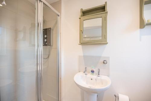 黑尔斯沃思Candy Cottage Halesworth Air Manage Suffolk的白色的浴室设有水槽和淋浴。