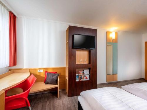 梅尔松根宜必思卡塞麦苏根酒店的酒店客房设有一张床、一张书桌和一台电视机。