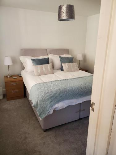 伊普斯威奇Ipswich Town Centre - Apartment 1的一间卧室配有一张带白色和蓝色枕头的大床