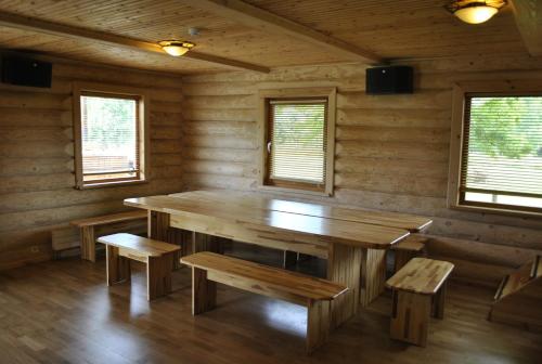 斯米尔泰内Vilks un Briedis Holiday Home & Wellness Area的一间带木桌和长凳的用餐室