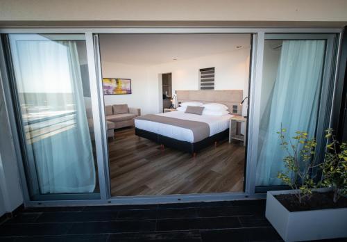 圣贝尔纳多Neco Boutique Hotel的一间卧室设有床和滑动玻璃门