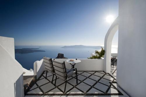 易莫洛林瓦莱斯别墅酒店的阳台配有桌椅,俯瞰着大海