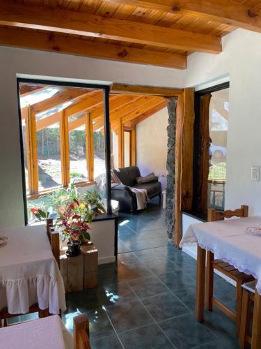 拉安戈斯图拉镇Acceso Bayo - ubicada en el acceso al cerro bayo 3km del centro的客厅配有两张桌子和一张沙发