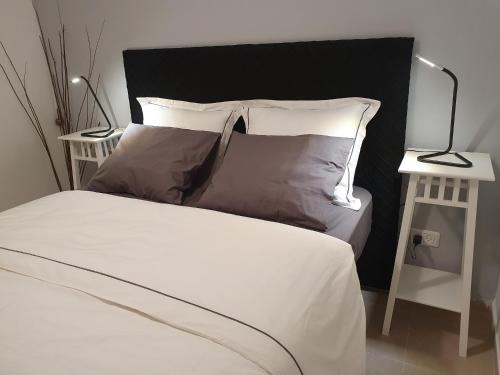拉马特甘אצל זיו的一间卧室配有带白色床单和枕头的床。
