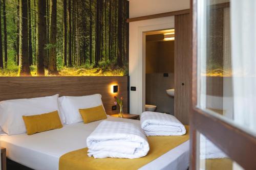 特伦托Hi Hotel - Wellness & Spa的卧室配有一张壁挂森林壁画的床