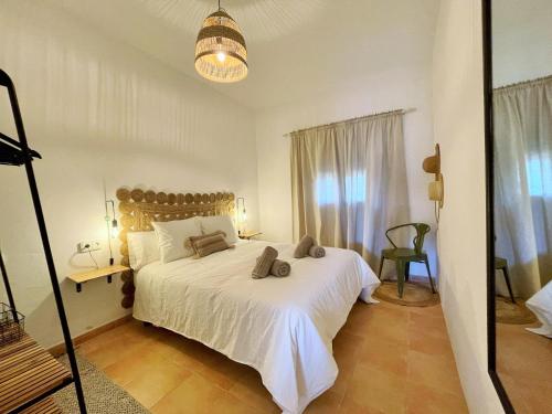 米乔尔海滩Apartamentos Carabela的卧室配有白色的床和窗户。