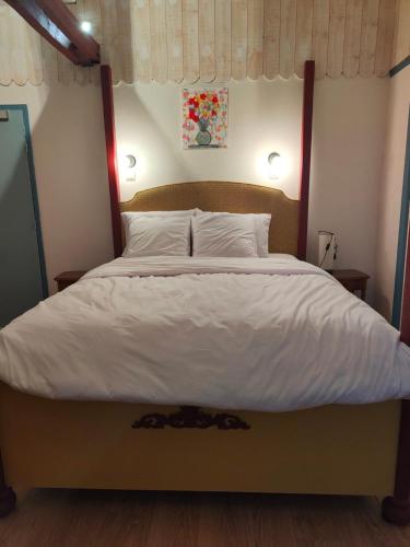ThenayL'auberge De Thenay的一间卧室配有一张带白色床单的大床