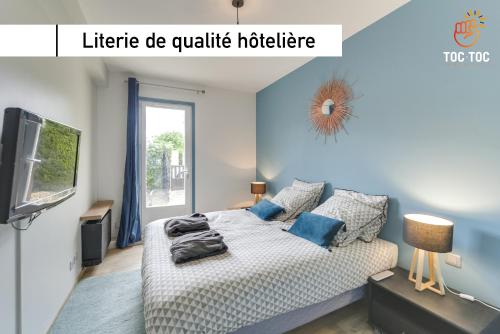 朗布依埃Le Coin de Marie à deux pas du centre ville的一间卧室配有一张蓝色墙壁的床和电视