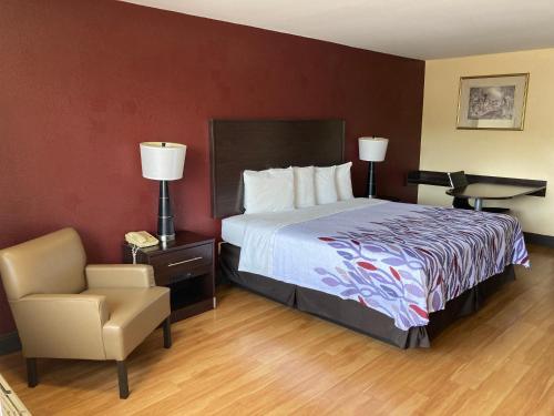 克利夫兰田纳西克利夫兰红屋顶客栈酒店的配有一张床和一把椅子的酒店客房