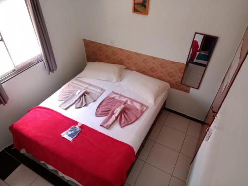 Colinas Do SulPousada Adorno的一间卧室,床上有粉红色的衣服