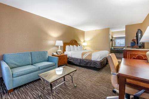 泰特斯维尔肯尼迪太空中心品质酒店的酒店客房,配有床和蓝色的沙发