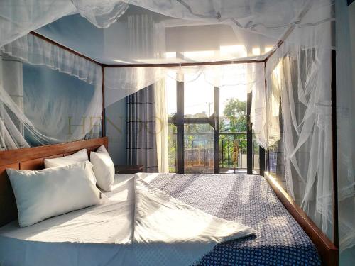 恩德培Hendo Hotel的一间卧室设有一张大床和大窗户