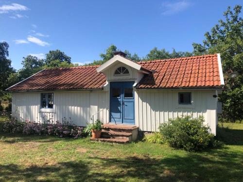 FröbygårdaSeaside Cottage Haga Park的一座白色的小房子,拥有橙色的屋顶