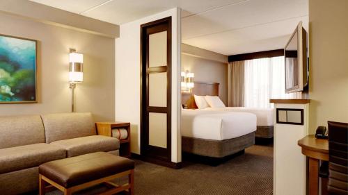 德卢斯Sonesta Select Atlanta Duluth的酒店客房,设有两张床和一张沙发