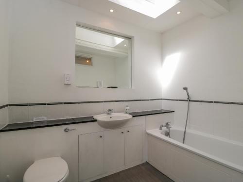 瓦灵福德Ninea的浴室配有盥洗盆、卫生间和浴缸。