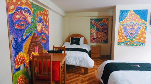 皮萨克Colores Hotel Apu-Linli的一间设有两张床的客房,墙上挂有绘画作品