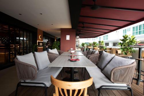 哥打京那巴鲁绿蔓酒店 – 万豪旅享家设计酒店品牌成员的庭院中设有1间带桌椅的餐厅