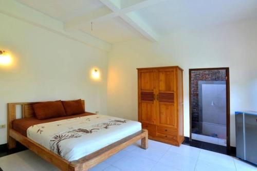 坎古Villa Family的一间卧室配有一张床和一个木制橱柜