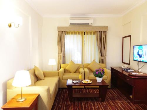 阿布扎比阿尔迪阿米娜酒店的客厅配有沙发和桌子