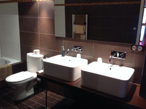 洛埃阿克拉吉贝希埃尔酒店的浴室设有2个水槽、卫生间和镜子。
