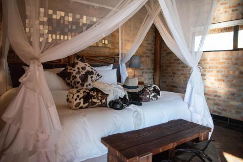 VryburgMorakane Safari Lodge的一间卧室配有一张带天蓬的白色床