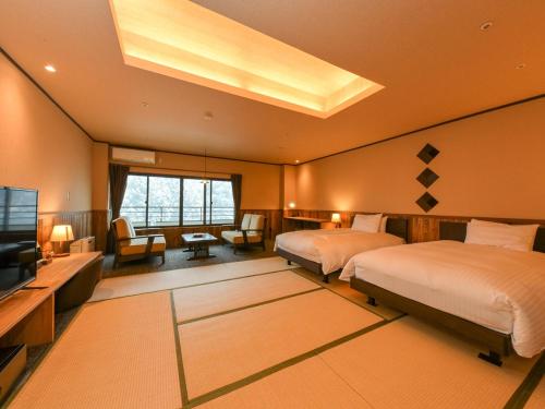 会津若松Kutsurogijuku Chiyotaki的一间大卧室,配有两张床和电视