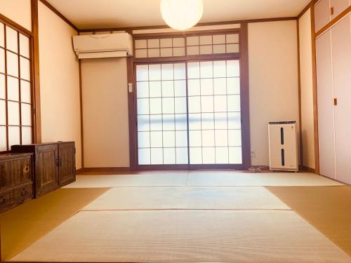 横滨Yokohama HY House的一间空房间,设有大窗户和大门