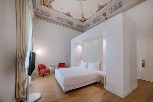佛罗伦萨佛罗伦萨罗萨港NH精选酒店的卧室配有白色的床和天花板