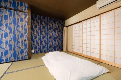 京都Daisenji Lodge Ing 藍 地下鉄鞍馬口駅から徒歩1分的一间拥有蓝色和白色墙壁的客房,配有一张床
