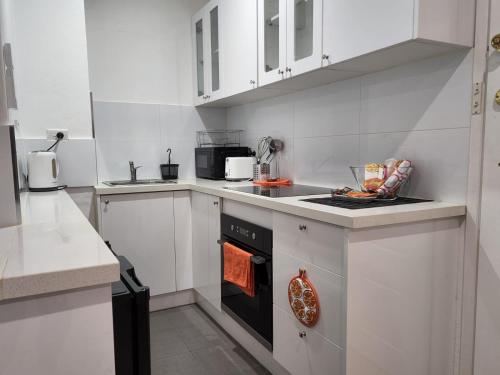 墨尔本St Kilda Lovely Studio Apartment的厨房配有白色橱柜和烤箱。