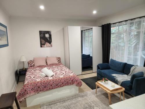 墨尔本St Kilda Lovely Studio Apartment的一间卧室配有一张床和一张沙发