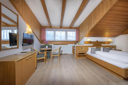 纳莱斯威尔玛酒店 的一间卧室配有一张床和一张书桌及电视