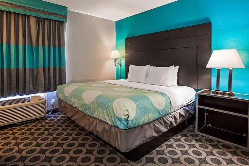 圣安东尼奥Travelodge by Wyndham San Antonio Downtown Northeast的酒店客房设有一张大床和蓝色的墙壁。