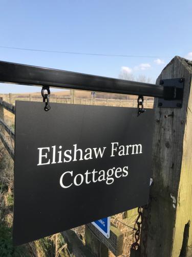 奥特本Elishaw Farm Holiday Cottages的阅读伊丽莎白农场小屋的标志