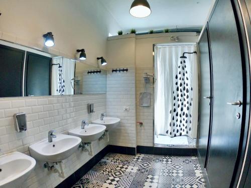 米兰QUO Milano的一间带三个盥洗盆和淋浴的浴室
