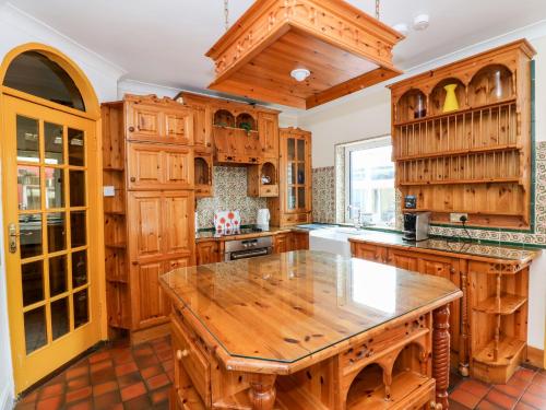 罗斯莱尔Ballysheen House的厨房配有木制橱柜和木桌。