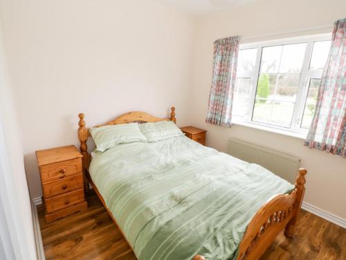 Dromore WestDromore West Cottage的一间卧室设有一张床和一个窗口
